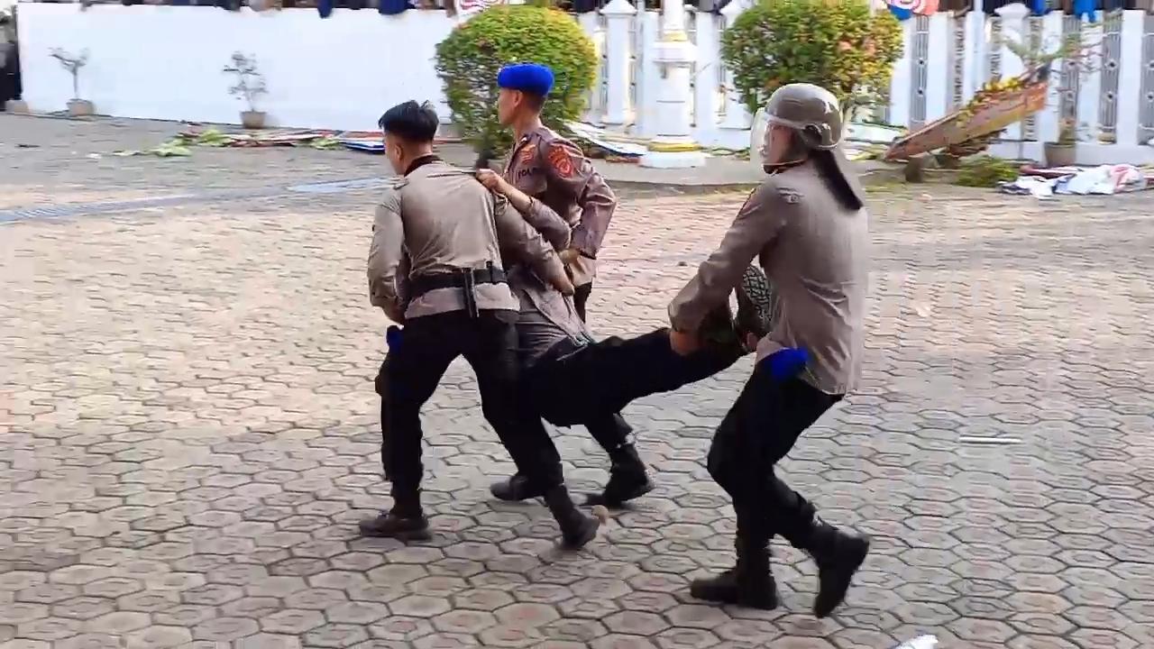 Seorang-polisi-dan-mahasiswa-tertangkap-kamera-sedang-dibantu-oleh-rekannya.jpg