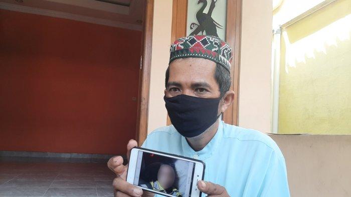 budiman-memperlihatkan-foto-anaknya-yang-meninggal-setelah-makan-sate-misterius.jpg