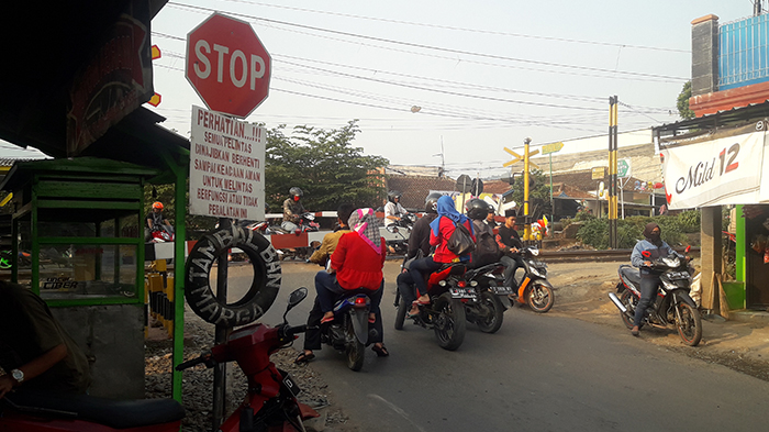 sejumlah-pengguna-kendaraan-roda-dua-tampak-menerobos-palang-pintu-kereta-api_20180711_193011.jpg