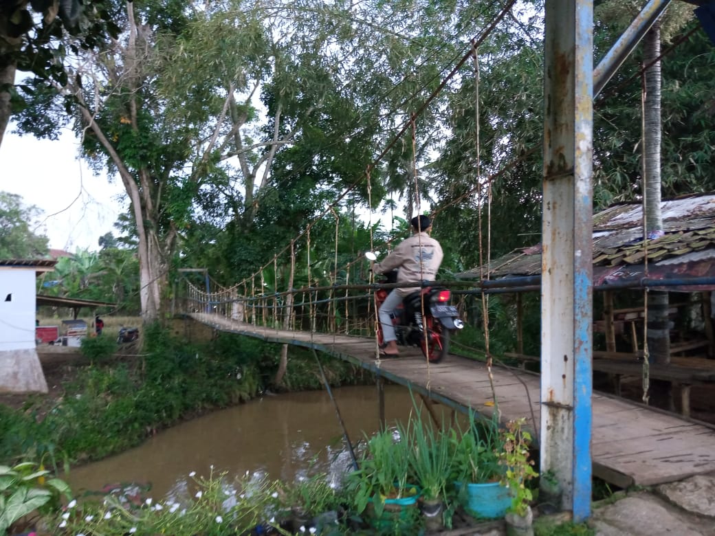 seorang-warga-melintas-di-jembatan-sungai-leuwi-panjang-di-sukabumi.jpg