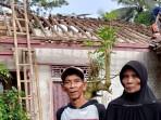 Hendar-dan-Maemunah-berdiri-di-depan-rumahnya-yang-sebagian-atapnya-ambruk.jpg