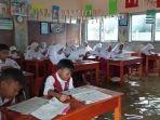Para-murid-ujian-sekolah-di-tengah-genangan-banjir-di-SD-Negeri-1-Cangkring.jpg
