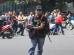 pria-tak-dikenal-dengan-senjata-berjalan-dengan-latar-kerumunan_20160115_104500.jpg