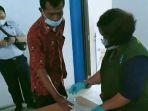seorang-kru-bus-menyerahkan-sampel-air-seni-kepqda-petugas-tes-urine.jpg
