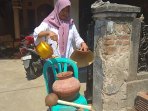 uniah-saat-menuangkan-air-ke-dalam-kendi-yang-sengaja-diletakkan-di-depan-rumahnya_20180730_203030.jpg