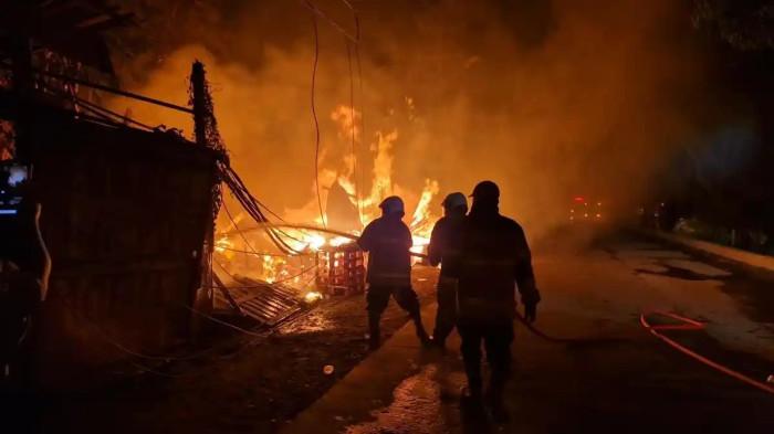 KEBAKARAN RUMAH SEMI PERMANEN - Puluhan petugas pemadam kebakaran berjibaku memadamkan kebakaran yang melanda sembilan bangunan semi permanen yang menjadi lapak barang bekas di Jalan Raya Prancis, Benda, Kota Tangerang, Banten, Rabu (25/2/2026) malam. (TribunTangerang.com/Gilbert Sem Sandro)