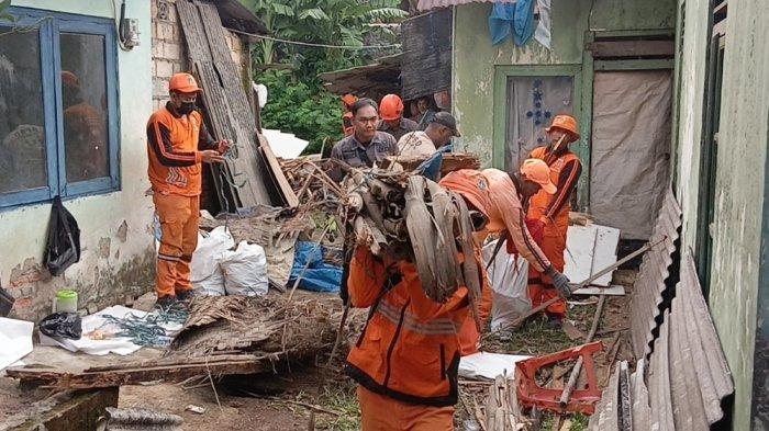 Petugas gabungan mengangkut puing material bangunan dua rumah warga RT 02/RW 08, Tengah yang atapnya ambruk, Kramat Jati, Jakarta Timur, Rabu (19/11/2025).