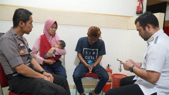 Andre (21) hanya menunduk ketika ditanya di kantor Polsek Tegalsari Surabaya, didampingi kakaknya, setelah menginjak kepala ibunya yang sedang terbaring sakit.