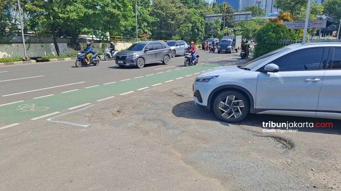 JALAN BERLUBANG - Salah satu jalan berlubang di Jalan S. Parman atau tepatnya di depan Mal Citraland pada Senin (26/1/2026) siang nampak sudah ditandai dengan cat putih agat pengendara lebih berhati-hati.