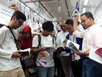 anies-baswedan-dan-direktur-pt-mrt-jakarta-william-sabandarsedang-membaca-buku.jpg