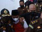 terdakwa-kasus-rudapaksa-13-santri-kota-bandung-herry-wirawan-diborgol-diapit-petugas-kejati-jabar.jpg