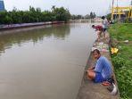 warga-berburu-ikan-di-aliran-kali-mookervart-jakarta-barat.jpg