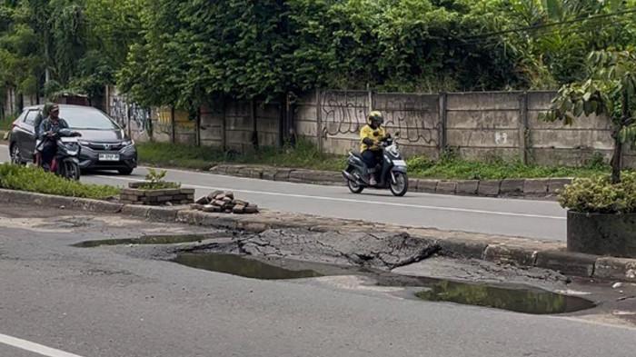 JALAN RUSAK - Potret kerusakan di Jalan Lingkar Barat Kota Jambi, Minggu (14/12/2025)