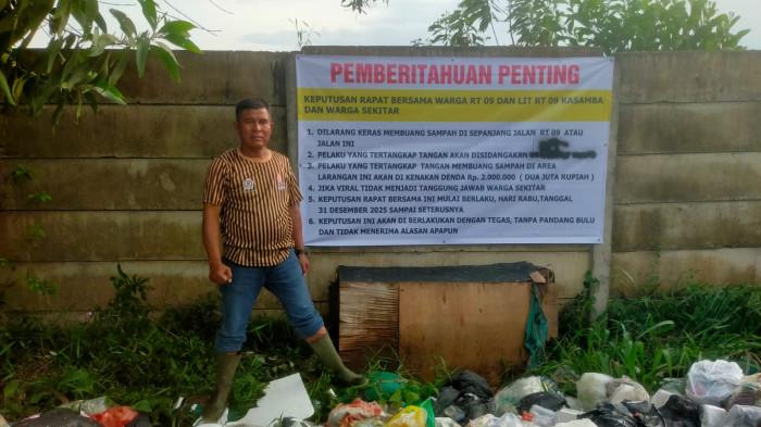 DENDA - Seorang warga menunjukkan kondisi sampah di RT 9 Kenali Asam Bawah, Minggu (4/1/2026). Kini warga menerapkan denda untuk orang yang membuang sampah sembarangan.