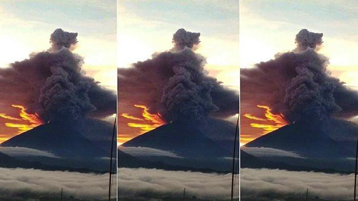 Ada Cahaya Kuning Kemerahan Diantara Kepulan Asap Gunung Agung yang Melambung Tinggi