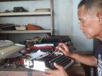 Syahrial-57-sedang-memperbaiki-mesin-tik-di-rumahnya-di-kawasa.jpg