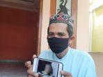 bandiman-memperlihatkan-foto-anaknya.jpg