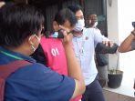 subhi-memakai-rompi-merah-saat-akan-dibawa-ke-mobil-tahanan-dan-dititipkan-ke-sel-polsek-telanaipura.jpg