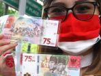 warga-memperlihatkan-uang-kertas-baru-pecahan-rp-75000.jpg