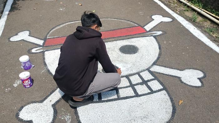 MURAL JALAN - Jalan di Perkampungan Kota Semarang melukis gambar Jolly Roger simbol bajak laut topi jerami, Sabtu (2/8/2025)