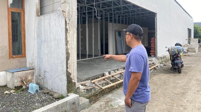PEMBANGUNAN DAPUR MBG - AB, warga Perumahan Kampung Rambutan Indah, Kalikabong, Purbalingga saat menujukan bekas tembok pembatas perumahan yang telah dijebol pengelola proyek pembangunan dapur MBG, Selasa (5/8/2025).