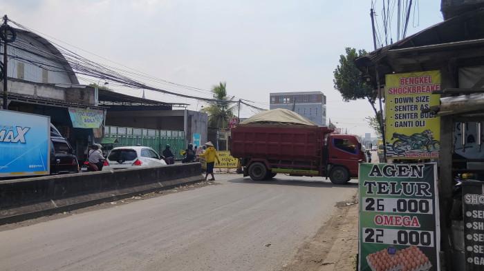 KELUHAN WARGA - Sebuah dump truk pembawa material menuju ke proyek tol Semarang-Demak nampak sedang memutar arah di jalan Bandungrejo Raya yang mengakibatkan kemacetan panjang, Jumat (3/10/2025).