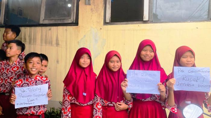 BAWA KERTAS ADUAN - Siswa SD Negeri Timbangreja 01, Kecamatan Lebaksiu, Kabupaten Tegal membawa kertas aduan kepada Bupati Ischak Maulana Rohman, Rabu (12/11/2025). Kondisi ruang kelas di sekolah itu memprihatinkan. Tembok rusak, atap tanpa plafon, hingga jendela jebol tidak ada jendela.