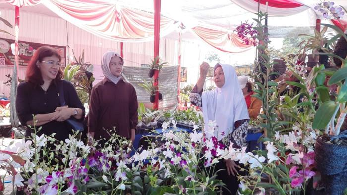 LAYANI PENGUNJUNG - Petani anggrek, Umi Kalsum melayani pengunjung saat pameran tanaman hias di halaman eks Wonderia Semarang, Rabu (19/11/2025). Dia menyebut telah menekuni usahanya sejak 2019, diawali secara autodidak.