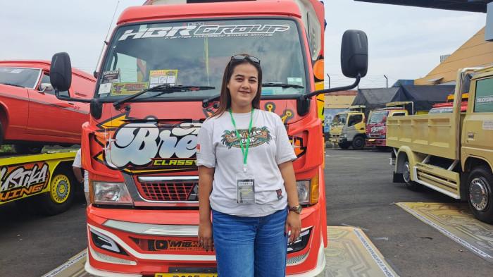 LADY DRIVER - Suci Caswati (28), warga asli Banyumas saat berfoto di depan truk dalam acara gelaran Jamnas 12 Canter Mania Indonesia Community (CMIC) di GOR Satria Purwokerto, Sabtu - Minggu (22 - 23/11/2025). Ia berbagi cerita bagaimana mereka tumbuh besar bersama Fuso sebagai pengemudi. 