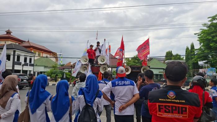 UNJUK RASA - Puluhan buruh di Kota Semarang melakukan aksi unjuk rasa di depan Balaikota, Senin (24/11/2025).
