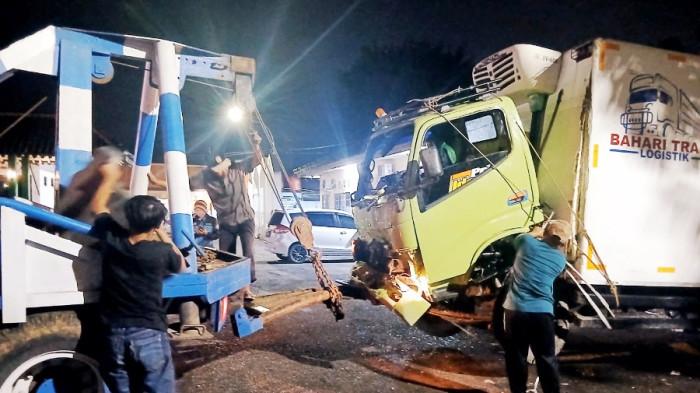 EVAKUASI - Proses evakuasi badan truk yang diduga mengalami rem blong dan masuk ke jalur penyelamat Dusun Prumbanan, Desa Purwojati, Kecamatan Kertek, Kabupaten Wonosobo, Selasa (16/12/2025). Tidak ada korban jiwa dalam peristiwa ini.