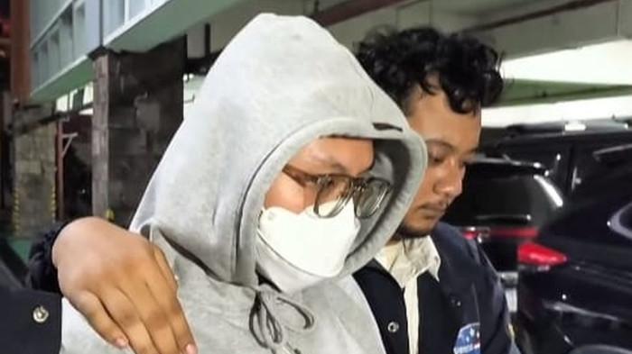 Streamer Resbob tiba di Bandara Soekarno-Hatta, Kota Tangerang, Senin (15/12/2025). Ia tiba dengan pengawal ketat dari pihak kepolisian. Perjalanan Kasus Streamer Resbob: Ujaran Kebencian yang Berujung Penangkapan.