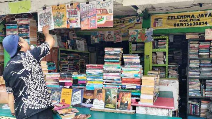 SEPI PEMBELI - Lapak buku Kawasan Stadion Timur Semarang terpantau sepi, Senin (12/1/2025). Pedagang sekadar berharap, menunggu datangnya pembeli sembari menata barang dagangannya.