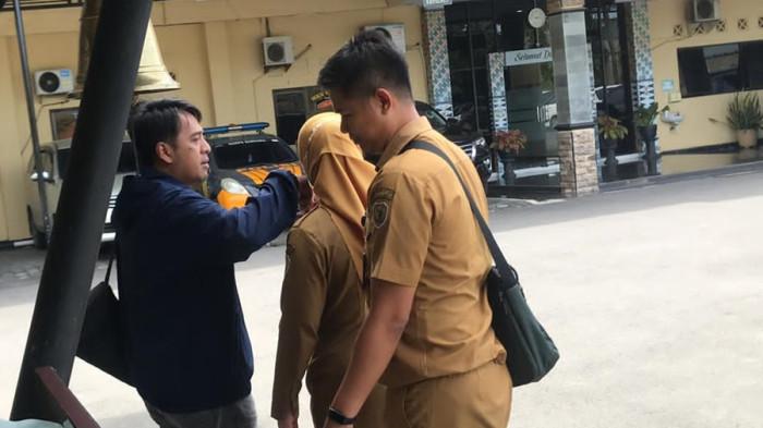 BERPAMITAN - Sekda Kabupaten Pekalongan M Yulian Akbar berpelukan dan berpamitan dengan istri di halaman Mapolres Pekalongan Kota, sebelum ikut masuk ke dalam bus yang menuju ke kantor KPK di Jakarta, Selasa (3/3/2026) sore.