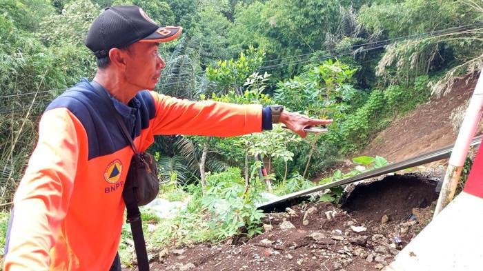 MEMASANG GARIS PEMBATAS - Petugas BPBD Brebes memasang garis pembatas di lokasi longsor pada Minggu 8 Maret 2026.