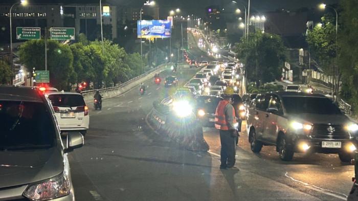 PADAT - Kepadatan kendaraan terjadi di Tanjakan Gombel Baru, Banyumanik, Kota Semarang, Minggu (19/4/2026) malam, saat median jalan mulai dipasang sebagai persiapan rekayasa dua arah. Petugas bersama warga setempat berjaga di tengah jalan mengatur arus lalu lintas di tengah proses pemasangan pembatas yang memicu antrean panjang dari arah Flyover Jatingaleh.