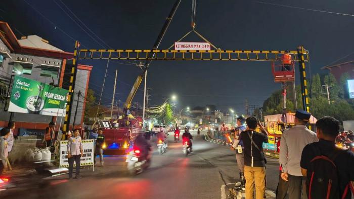 PASANG PORTAL: Dinas Perhubungan (Dishub) Kota Semarang kembali melakukan pemasangan portal pembatas kendaraan di kawasan simpang Jrakah, tepatnya di depan Pasar Jerakah, Purwoyoso, Kecamatan Ngaliyan, Kota Semarang, arah menuju BSB, Mijen, Selasa (28/4/2026) malam. (Tribun Jateng/Idayatul Rohmah)