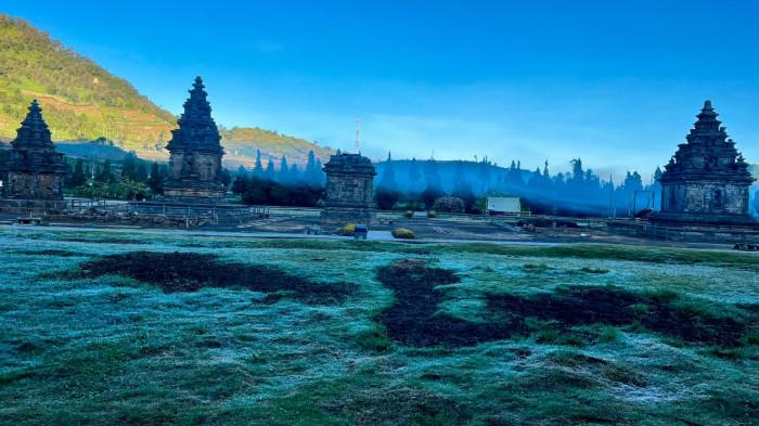 EMBUN ES - Embun upas atau embun es menyelimuti kawasan Kompleks Candi Arjuna, Dieng, Kabupaten Banjarnegara, Selasa (9/6/2026) pagi. Suhu terpantau di 0 hingga minus 1 derajat Celsius yang membentuk lapisan kristal es di rerumputan dan menjadi perhatian wisatawan yang datang.