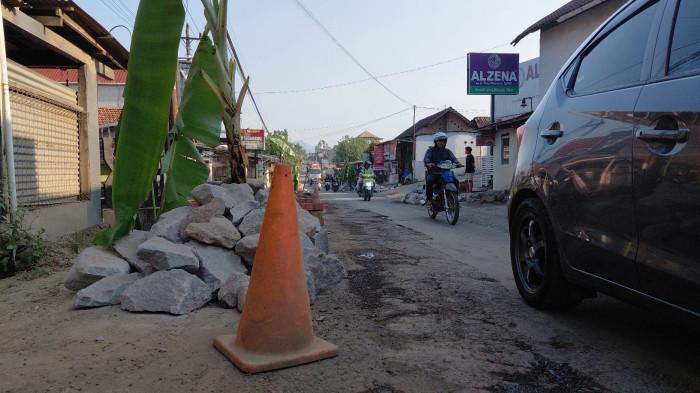 DIPASANG BATU - Jalan raya di Wringinputih, Kecamatan Bergas, Kabupaten Semarang dipasang batu sebagai bentuk protes warga terhadap kondisi jalan sekaligus meminimalisir kerusakan yang lebih parah, Kamis (11/6/2026)