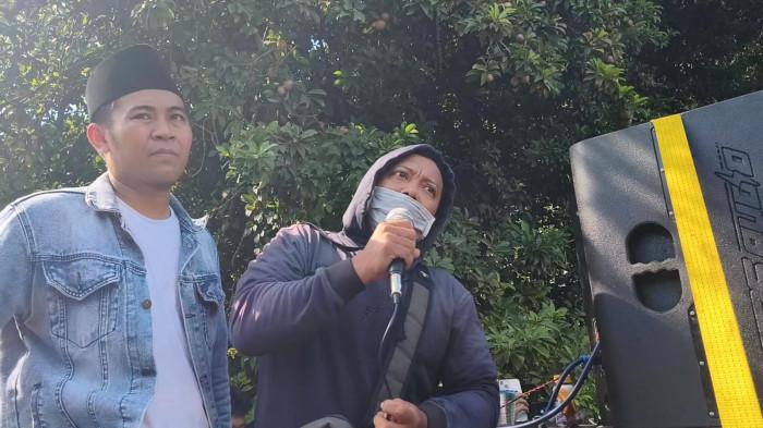 BERI KESAKSIAN - Shofi, pria yang mengaku korban pemerasan Ashari, memberikan kesaksian di tengah aksi unjuk rasa di depan kediaman Ashari yang juga pondok putri, Desa Tlogosari, Kecamatan Tlogowungu, Pati, Sabtu (2/5/2026). Untuk diketahui, Ashari merupakan pengasuh Pondok Pesantren Ndholo Kusumo yang terjerat kasus pencabulan santriwati