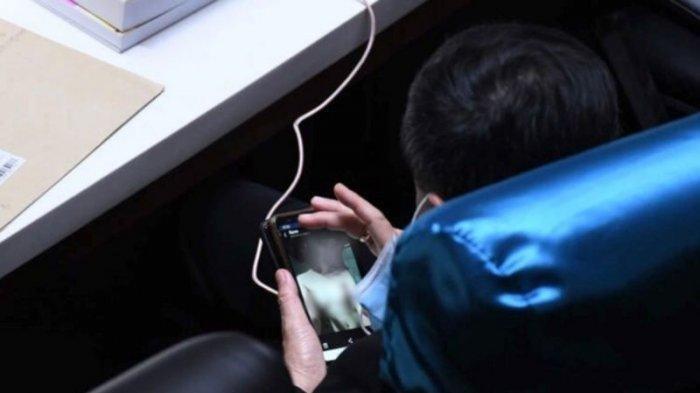 Ronathep Anuwat, anggota Dewan Perwakilan Rakyat (MP) Partai Palang Pracharat, Provinsi Chonburi tertangkap kamera melihat gambar wanita hampir telanjang saat di tengah rapat.