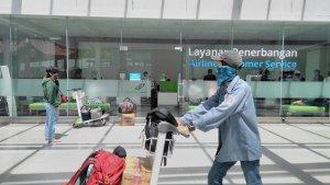 seorang-penumpang-yang-hendak-naik-pesawat-melintasi-ruang-pelayanan-penerbangan-di-band.jpg