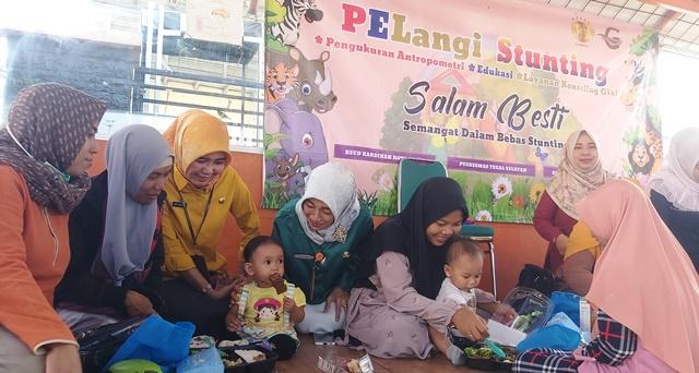 dr-Lenny-Harlina-Herdha-Santi-baju-hijau-secara-langsung-mendampingi-pemberian-makanan-bergizi.jpg