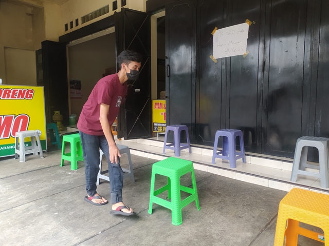 karyawan-warung-makan-menata-kursi-untuk-pembeli-dengan-sistem-take-away.jpg