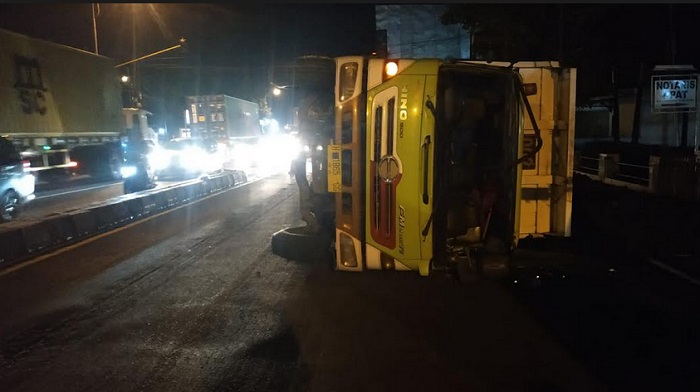 Diduga Sopir Mengantuk, Truck Terguling di Tengah Jalan setelah Tabrak Pembatas Jalan