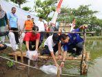 Edy-Sujatmiko-menabur-benih-ikan-nila-merah-di-area-Pemancingan-Kartini.jpg