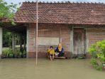 Fatiya-menyuapi-anaknya-di-tengah-kepungan-banjir-Desa-Kalianyar.jpg