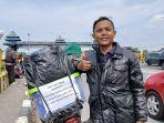 Pemudik-sepeda-motor-dari-Cileungsi-Bogor-Iwan-saat-berfoto-di-Gapura-Selamat-Datang-Kota-Tegal.jpg