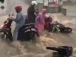 Pengendara-sepeda-motor-terjatuh-karena-terseret-banjir.jpg