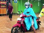 Polisi-membantu-pesepeda-motor-melintasi-banjir.jpg